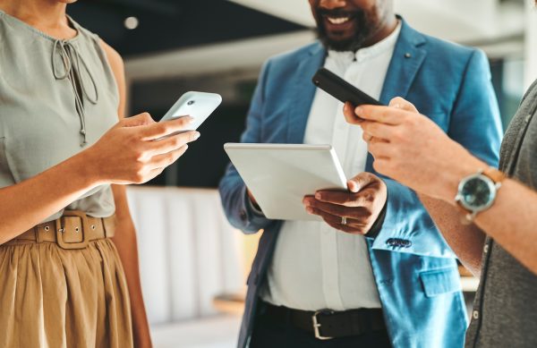 Diversity in work team using internet on phones and digital tablet for teamwork growth in the office. Professional staff work with 5g technology to match work schedule online the company website