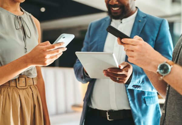 Diversity in work team using internet on phones and digital tablet for teamwork growth in the office. Professional staff work with 5g technology to match work schedule online the company website