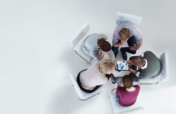High angle view of businesspeople using digital tablet together in office