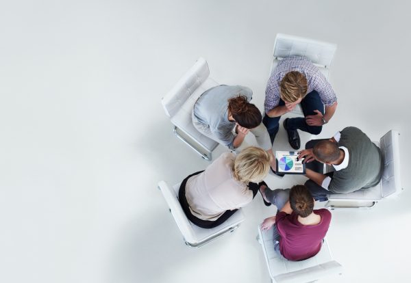 High angle view of businesspeople using digital tablet together in office