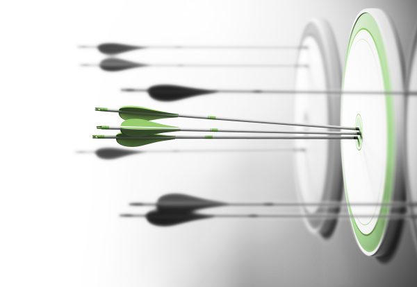 Three targets with focus on the one in the center and arrows hitting the center. Concept of competitive excellence and performance.