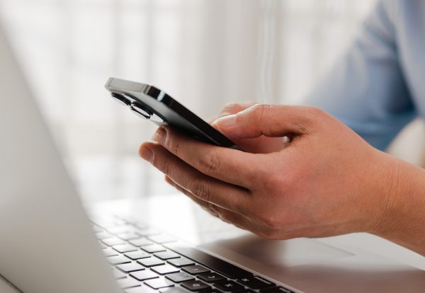 Businessman holding smartphone  and working on laptop